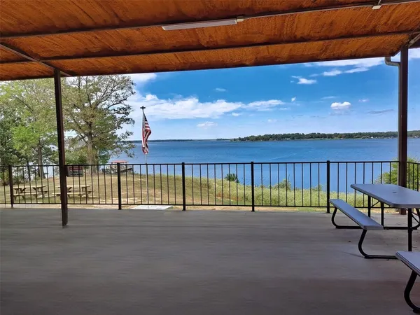 a view of a park with lawn chairs and large trees