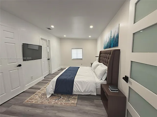 a bedroom with a bed and a flat screen tv