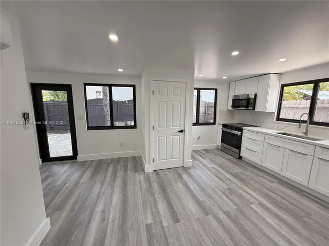 a view of a large kitchen with wooden floor and a sink