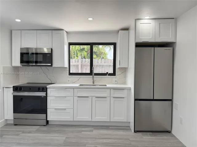 a kitchen with appliances a sink and a microwave