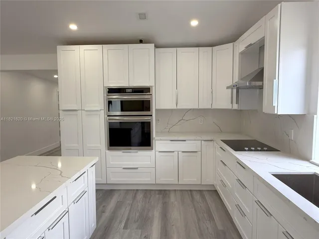 a kitchen with granite countertop a sink a microwave and cabinets