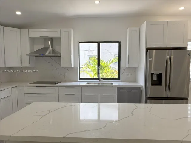 a kitchen with stainless steel appliances a refrigerator and a sink