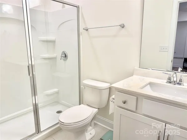 a bathroom with a sink toilet vanity and shower