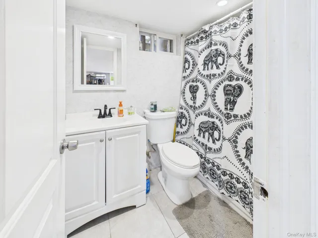 a white toilet sitting next to a white sink and vanity