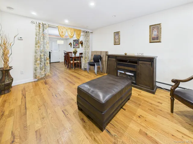 a living room with stainless steel appliances kitchen island granite countertop furniture and a wooden floor