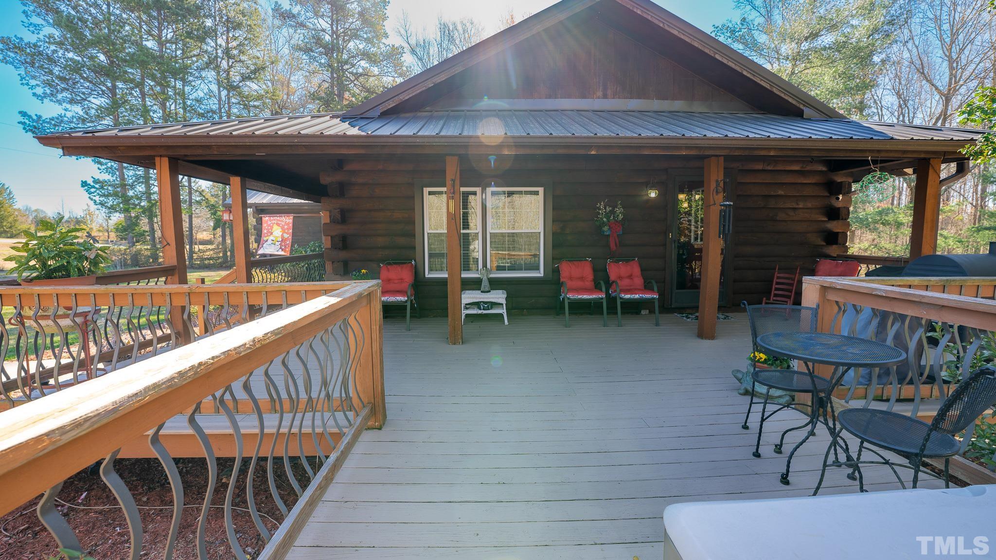 714 Lucy Garrett Road Roxboro, NC 27574 - Photo 14 of 68 a view of a patio with table and chairs potted plants with wooden floor and fence