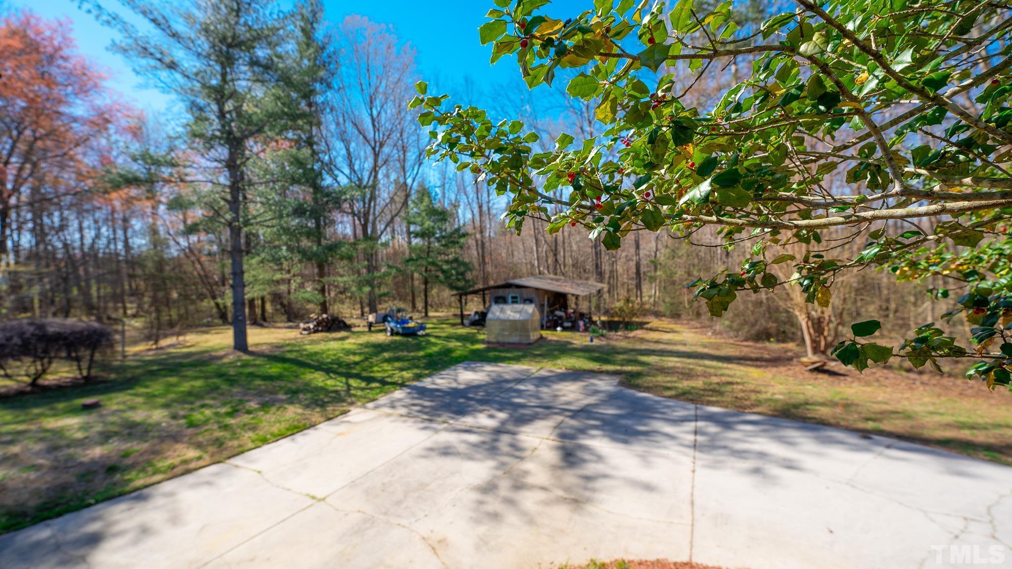 714 Lucy Garrett Road Roxboro, NC 27574 - Photo 66 of 68 a view of a yard with plants and trees