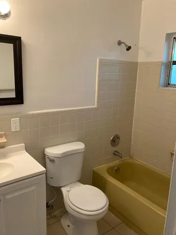 a white toilet sitting next to a bath tub