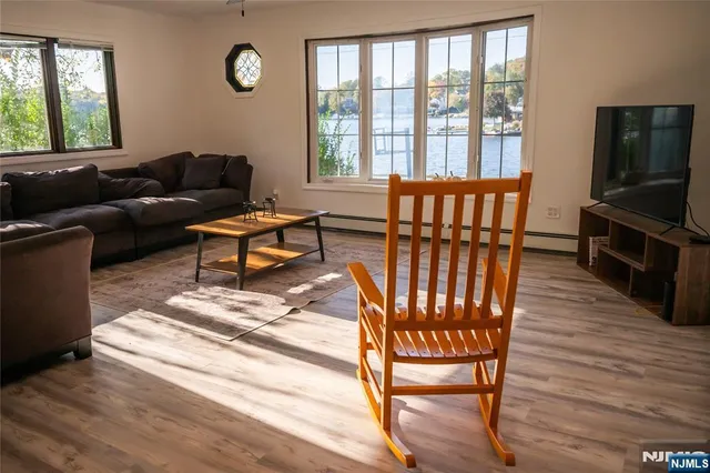 a living room with furniture a flat screen tv and a window