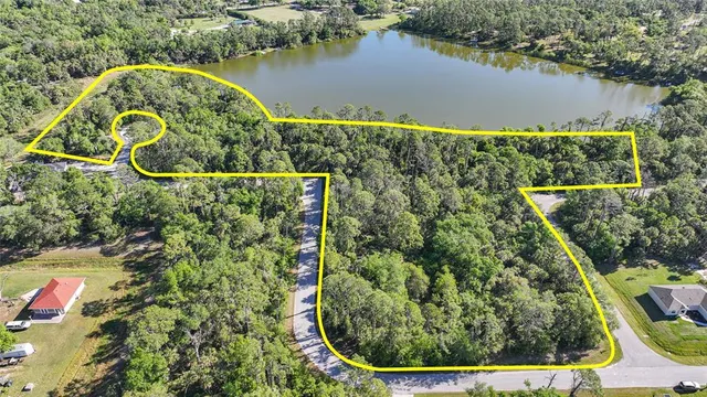 an aerial view of a residential houses with outdoor space and lake view