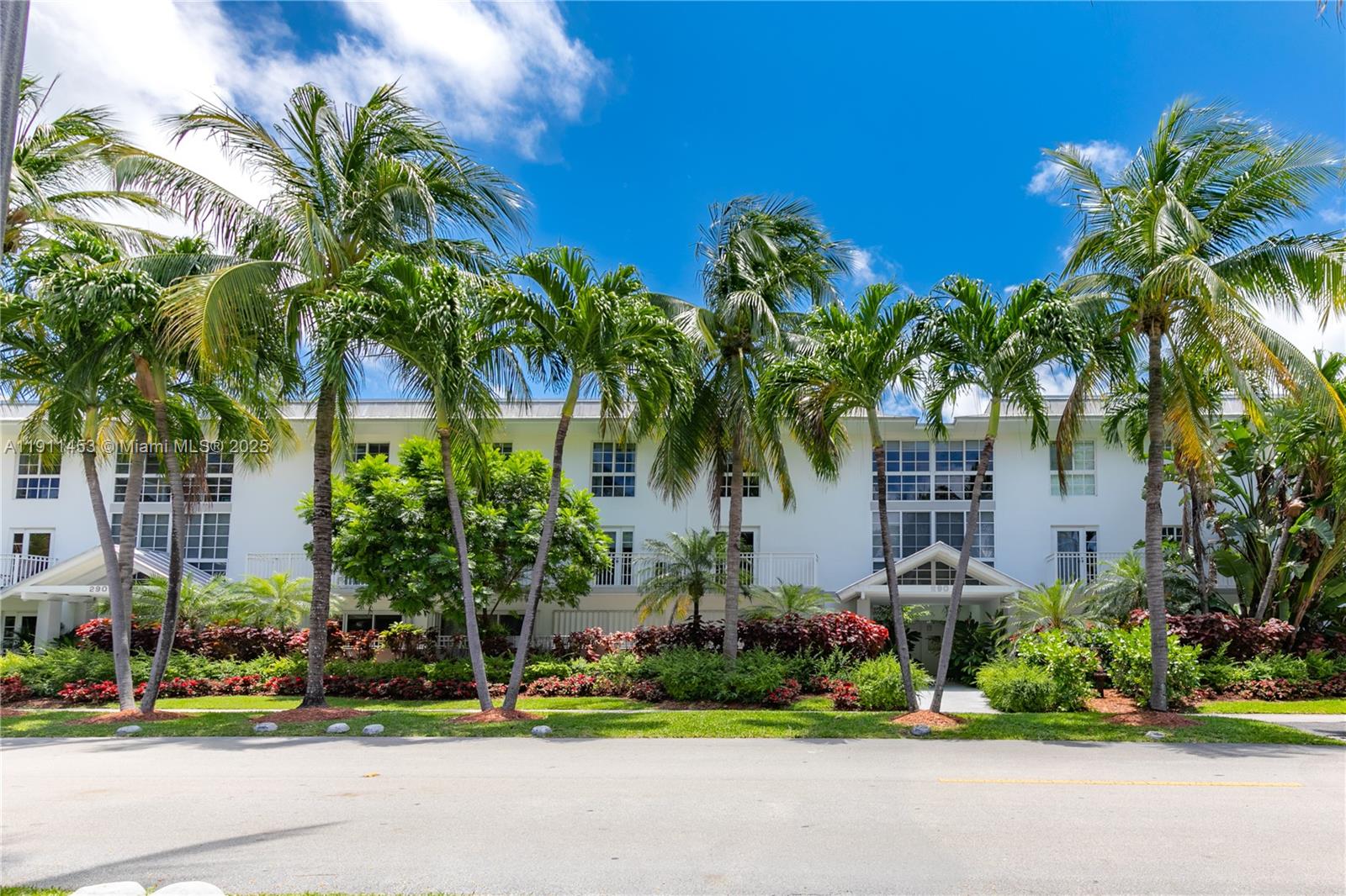 290 Sunrise Drive, Unit 3F Key Biscayne, FL 33149 - Photo 18 of 19 a front view of multi story residential apartment building with yard and sign board