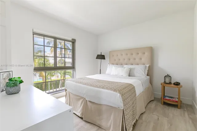 a bedroom with a bed and a large window