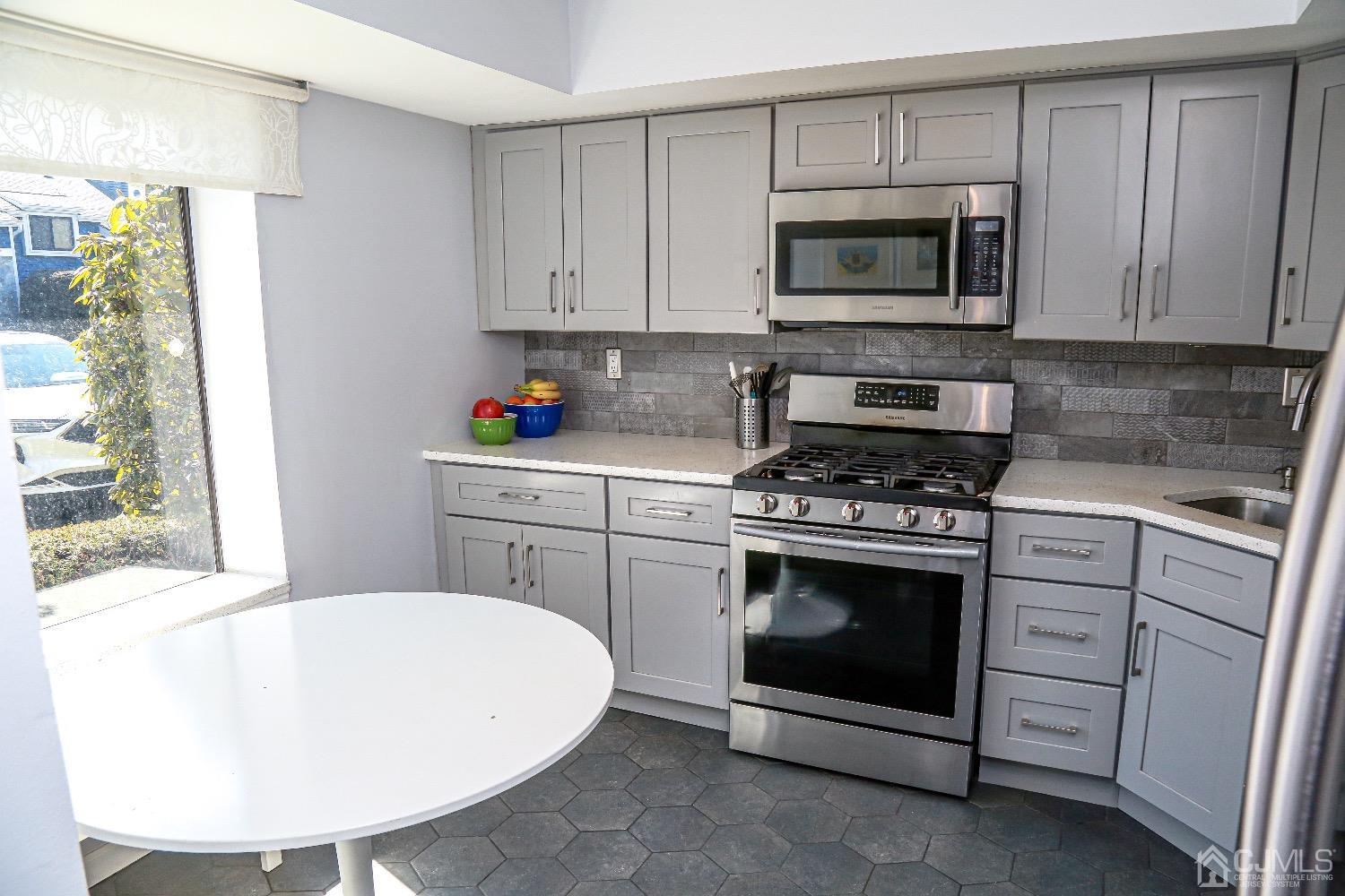 5805 Hana Road Edison, NJ 08817 - Photo 8 of 40 a kitchen with stainless steel appliances a stove a microwave a sink and cabinets