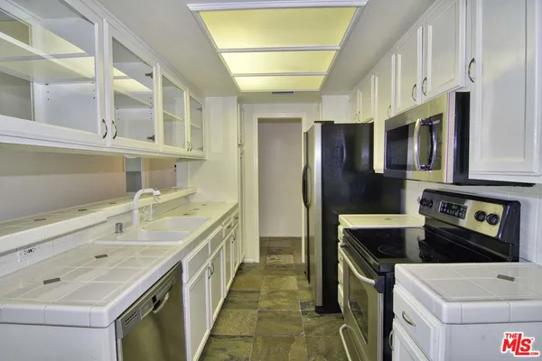 a kitchen with stainless steel appliances a sink stove and refrigerator