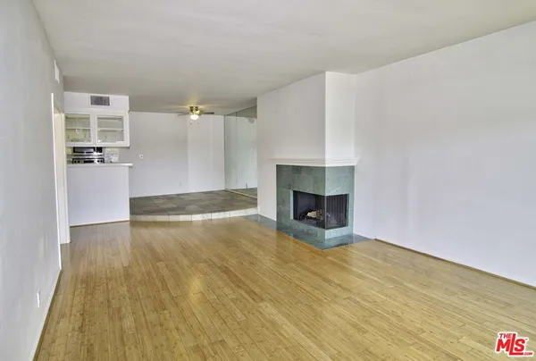 a view of empty room with wooden floor and fireplace