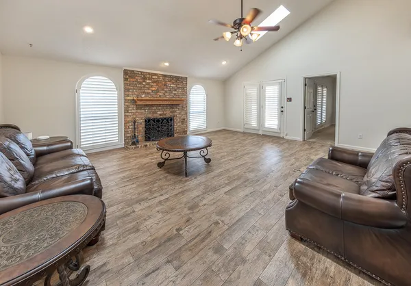 a living room with furniture a fireplace and a chandelier