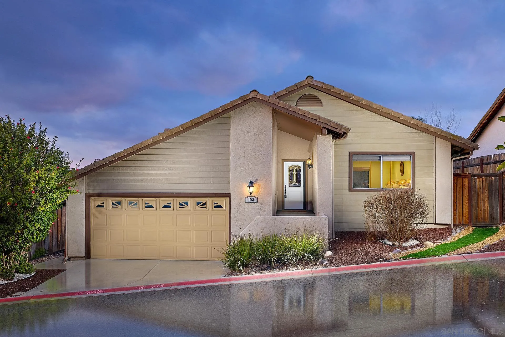 a view of a white house with large windows and palm trees