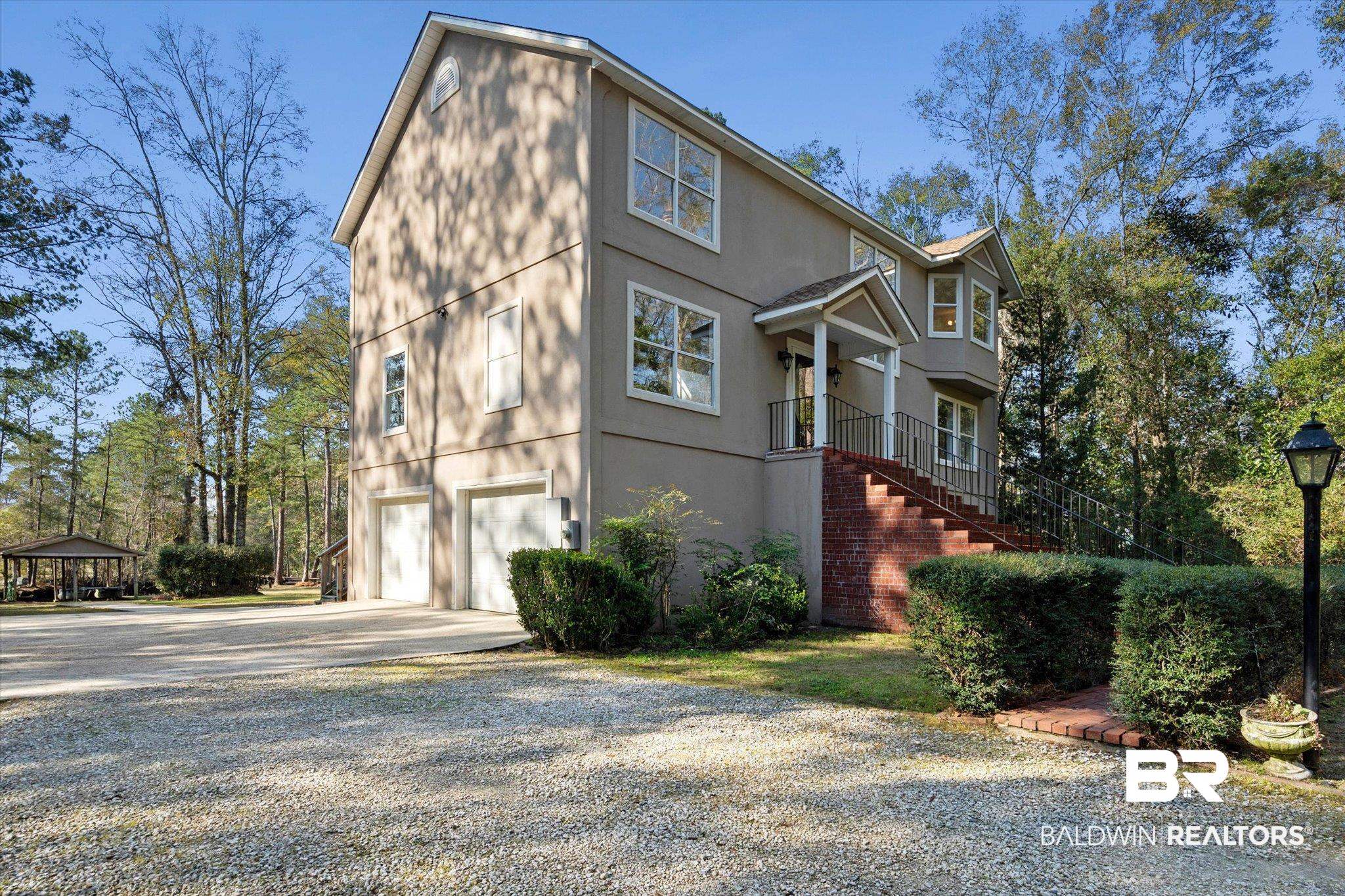 3847 Riviere Du Chien Road Mobile, AL 36693 - Photo 6 of 51 View of side of property featuring concrete driveway, an attached garage, and stucco siding
