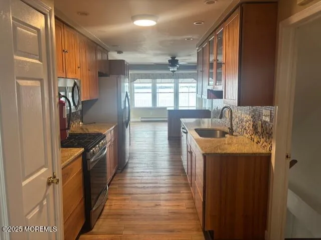 a kitchen with granite countertop a sink stove and refrigerator