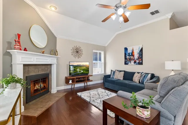 a living room with furniture a fireplace and a flat screen tv