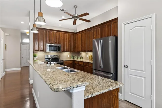 a kitchen with stainless steel appliances granite countertop a sink refrigerator and microwave