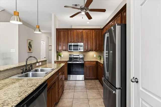 a kitchen with stainless steel appliances granite countertop a sink refrigerator and cabinets
