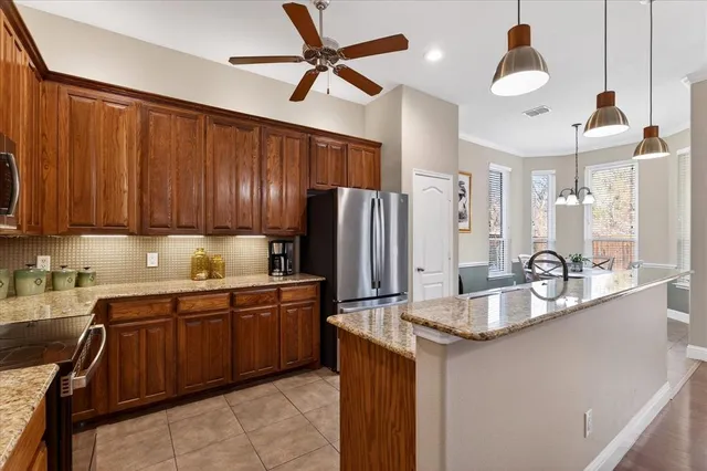 a kitchen with stainless steel appliances granite countertop a sink refrigerator and cabinets