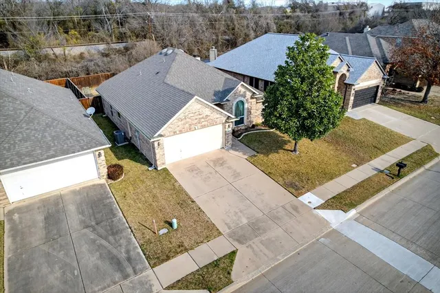 an aerial view of a house with swimming pool and large trees