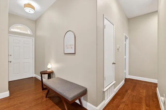 a view of a room with wooden floor cabinet and hallway