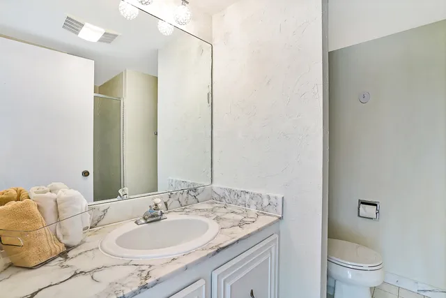 a bathroom with a granite countertop sink and a mirror