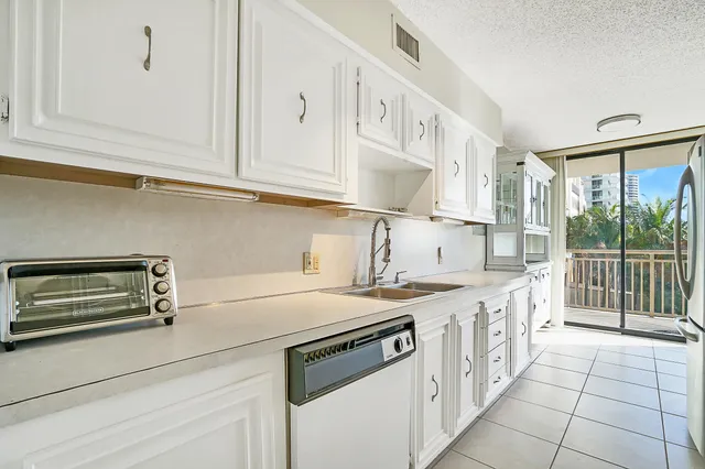 a kitchen with granite countertop a sink a stove and cabinets
