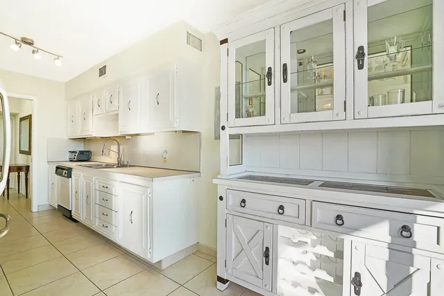 a kitchen with granite countertop white cabinets and white appliances