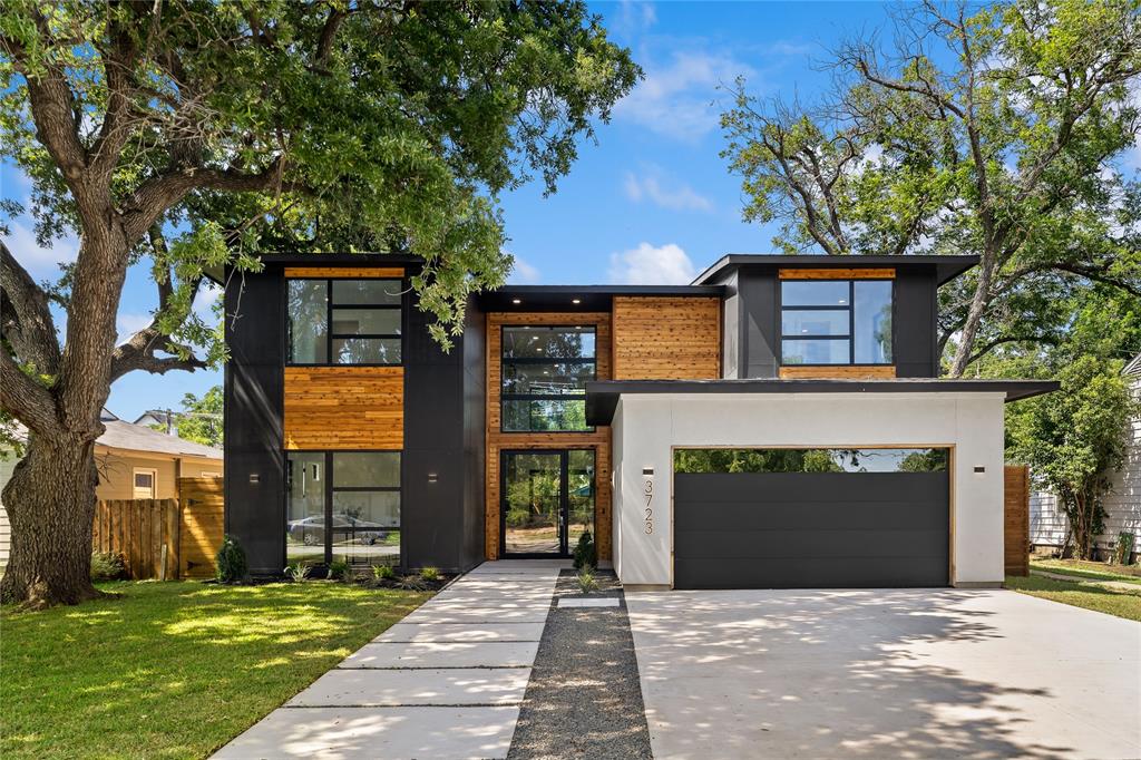 Contemporary home featuring a garage and a front lawn