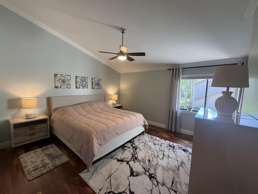 5560 Coach House Circle, Unit C Boca Raton, FL 33486 - Photo 18 of 31 a bedroom with a large bed and a chandelier