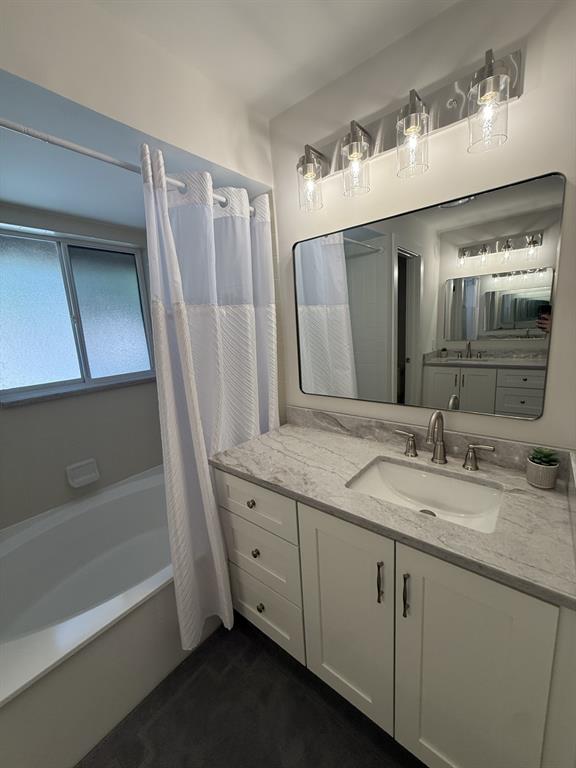 5560 Coach House Circle, Unit C Boca Raton, FL 33486 - Photo 24 of 31 a bathroom with a granite countertop sink a mirror and a bathtub
