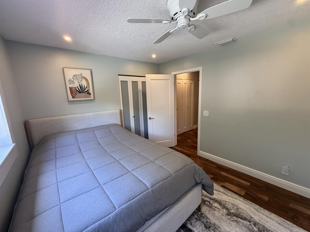 5560 Coach House Circle, Unit C Boca Raton, FL 33486 - Photo 26 of 31 a bedroom with a large bed and a chandelier