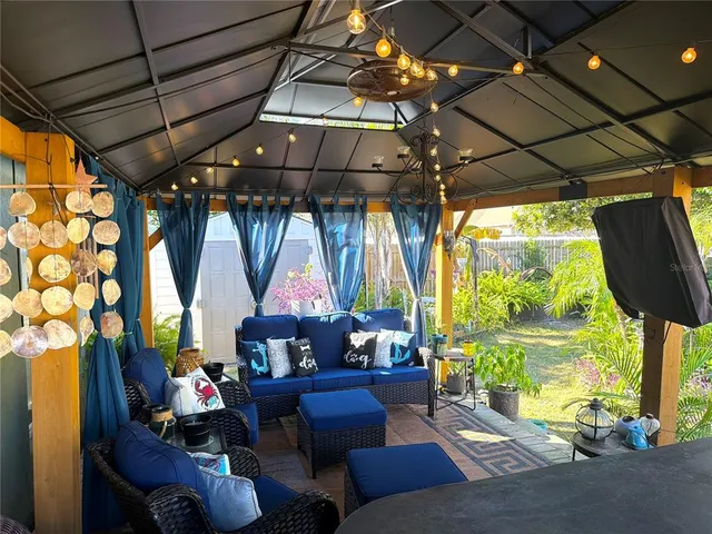 a living room with patio furniture and a large window