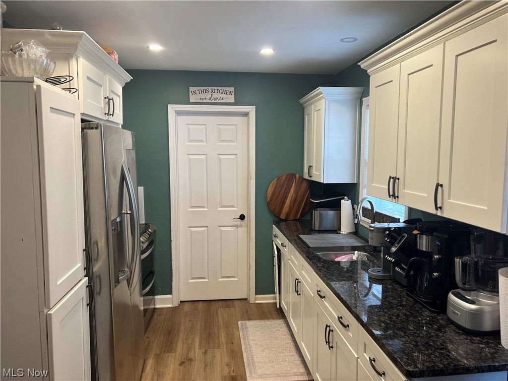 146 Stephens Road Akron, OH 44312 - Photo 11 of 31 Kitchen featuring white cabinets, dark stone counters, hardwood / wood-style floors, and stainless steel fridge with ice dispenser