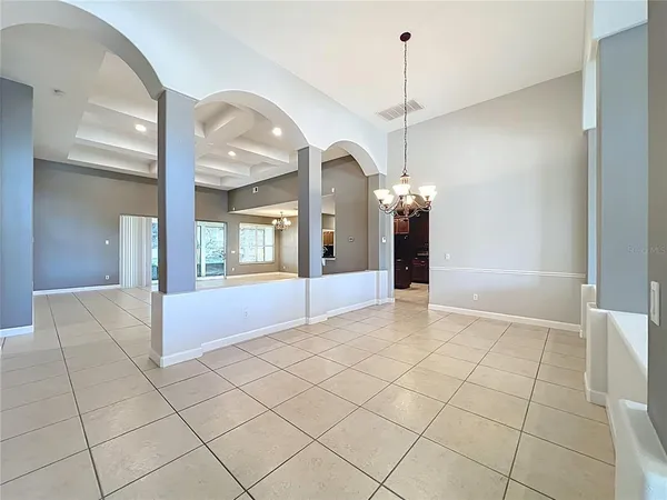 a view of a hallway with wooden floor and a chandelier