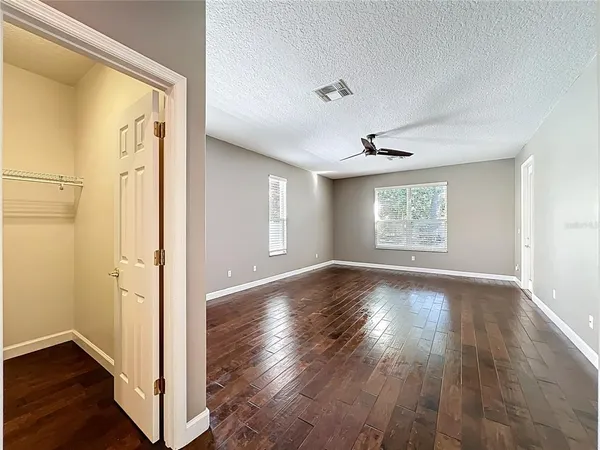 a view of an empty room with window and wooden floor