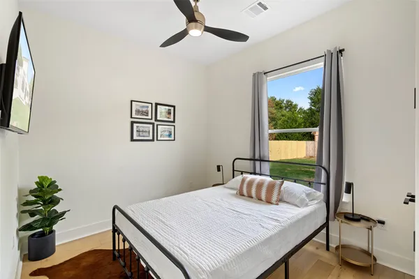 a bedroom with a large bed and a chandelier