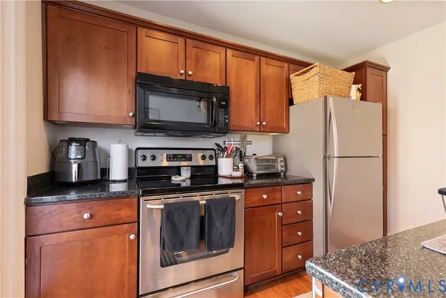a kitchen with granite countertop a refrigerator stove and microwave