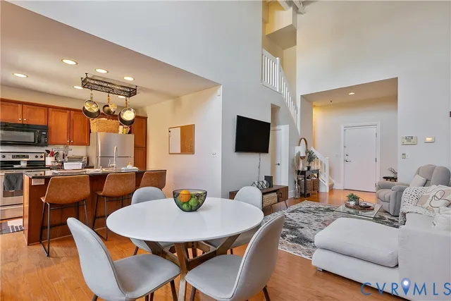 a living room with furniture kitchen and a flat screen tv