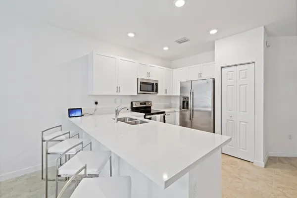 a kitchen with stainless steel appliances a refrigerator stove microwave and white cabinets