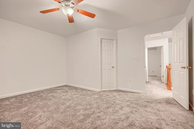 an empty room with closet and a chandelier fan
