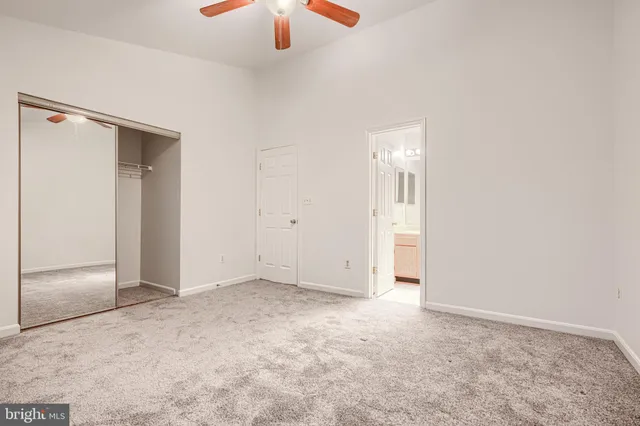 an empty room with closet and a chandelier fan