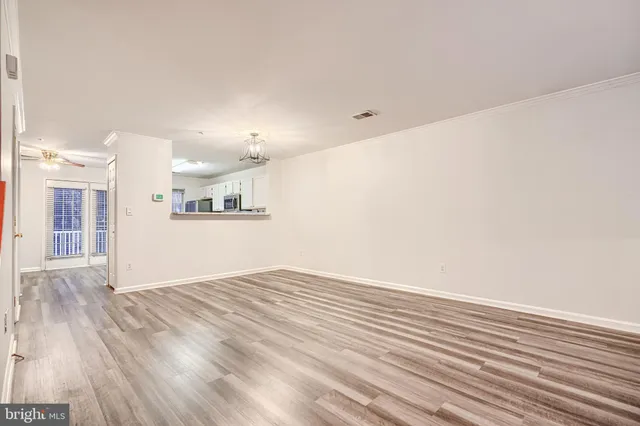 a view of a kitchen with wooden floor and a ceiling fan