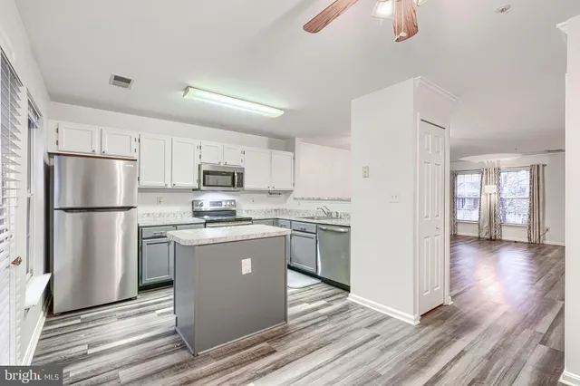 a kitchen with stainless steel appliances granite countertop a refrigerator a stove top oven a sink and dishwasher