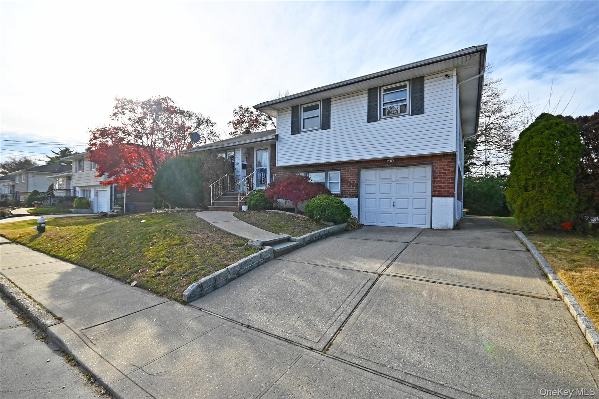 89 Osborne Road West Hempstead, NY 11552 - Photo 2 of 50 Split level home featuring brick siding, driveway, an attached garage, and a front lawn