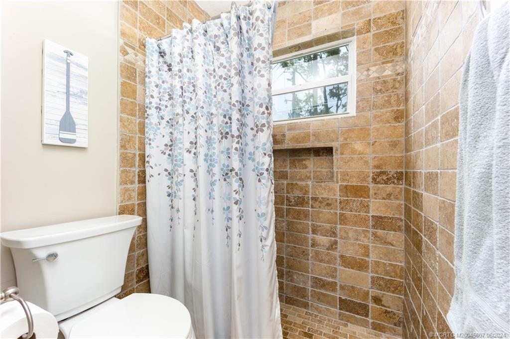 4642 Southeast Shady Ridge Lane Stuart, FL 34997 - Photo 17 of 34 Step in shower in the primary bathroom